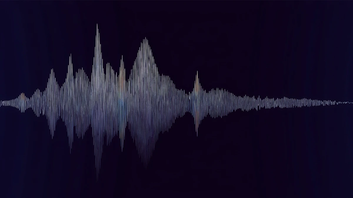 An audio waveform on a dark background with a faint, glowing digital signature woven invisibly through its peaks and troughs, visible only as a subtle shimmer across the frequency spectrum.